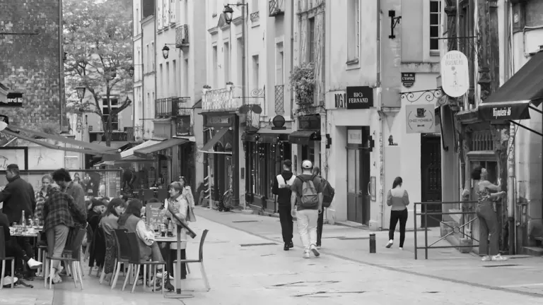 Ambiance animée en terrasse dans une rue commerçante du centre-ville d'Angers.