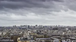 Vue panoramique des toits de Paris sous un ciel orageux et chargé de nuages.