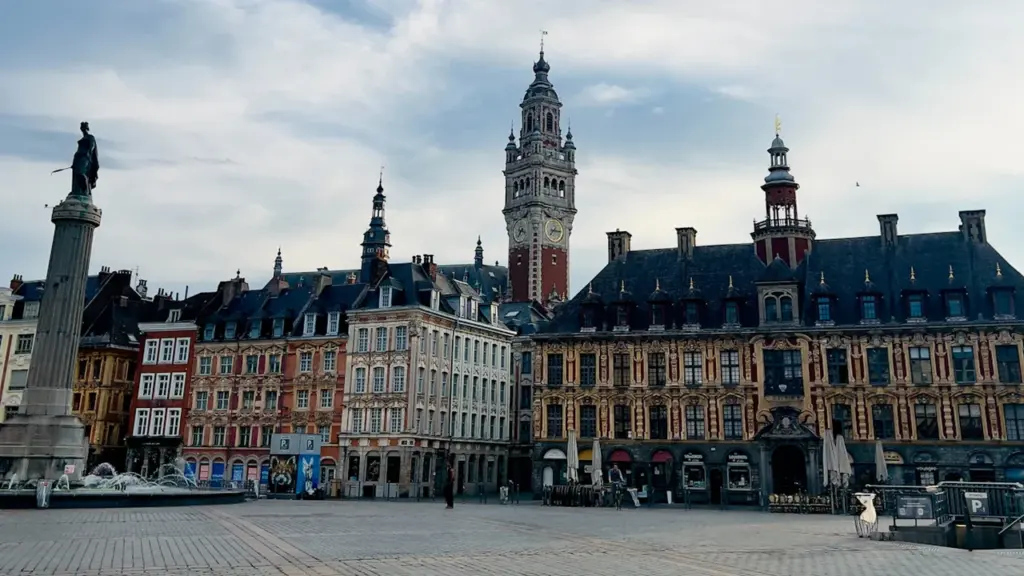 Vue d'ensemble d'une grande place historique lilloise avec son beffroi et monuments.