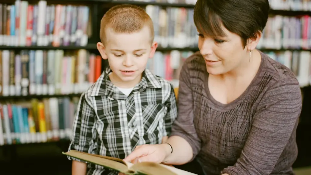 Une mère lit un livre avec son jeune fils dans une bibliothèque publique.