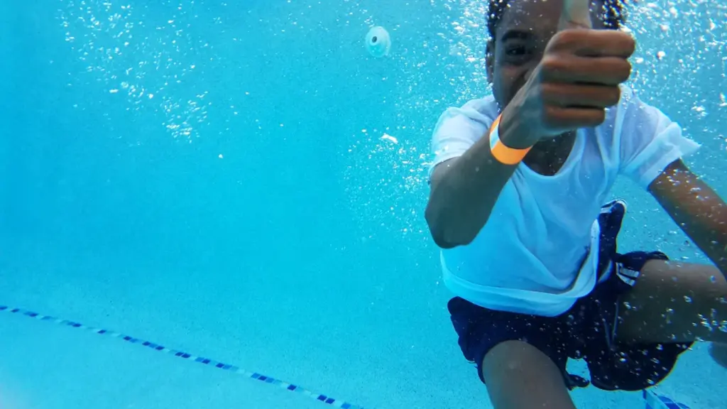Un jeune garçon en plein apprentissage de la natation sous l'eau à la piscine.