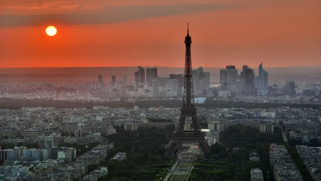 Vue aérienne de la tour Eiffel sous un soleil couchant intense et orangé.