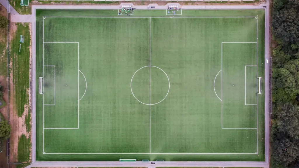 Vue aérienne d'un terrain de football dégagé pour illustrer les défis de stationnement.