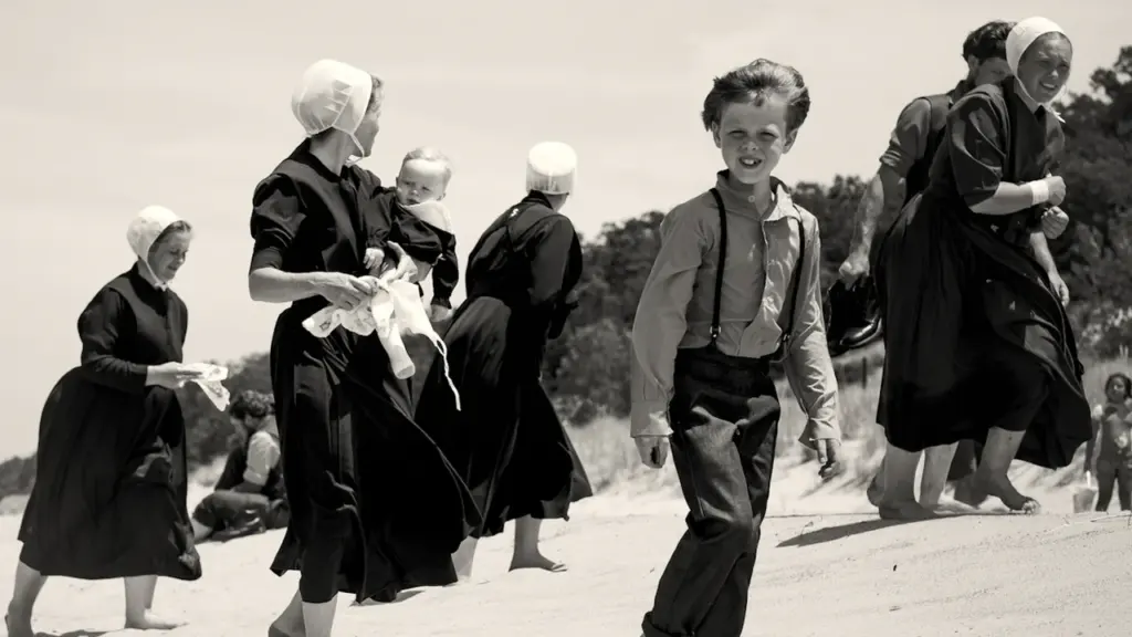 Personnes en habits traditionnels marchant sur une plage, évoquant l'esprit festif breton.