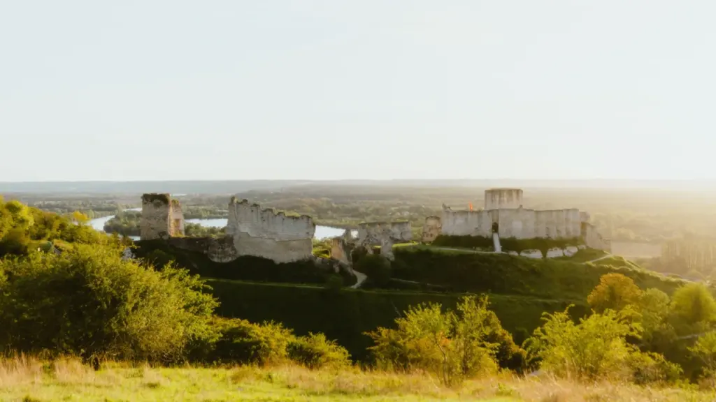 Paysage verdoyant avec des ruines historiques au loin en France.