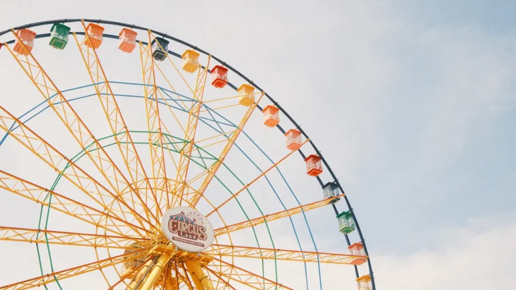 Grande roue colorée contre un ciel clair pour un événement festif à Grenoble.